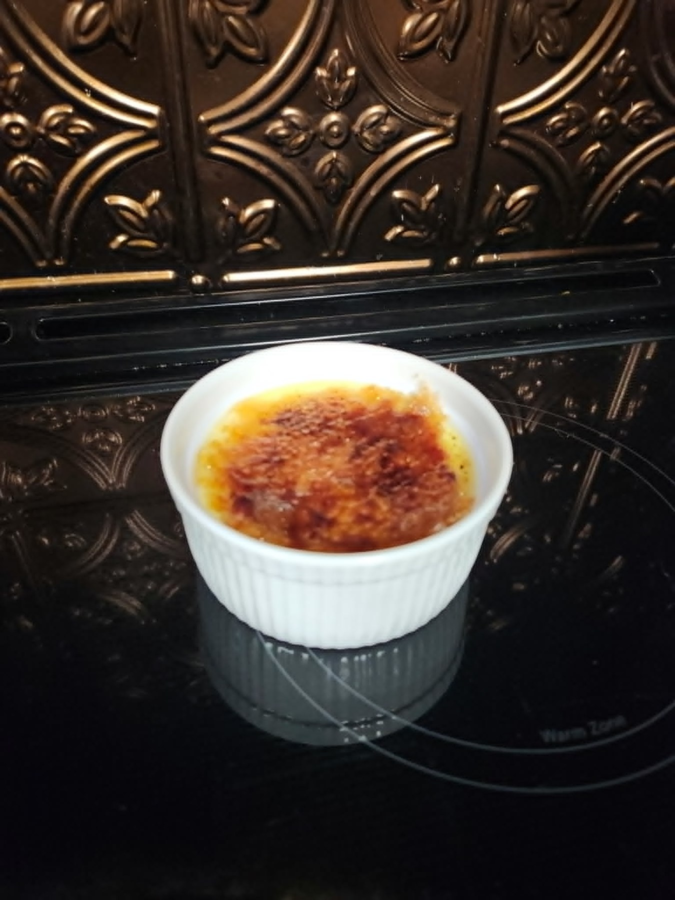 Individual crème brûlée in a white ramekin