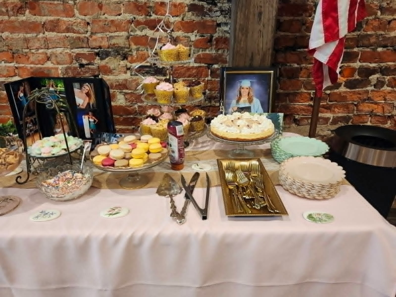 Graduation dessert table with cupcakes, cookies, cake, and serving pieces