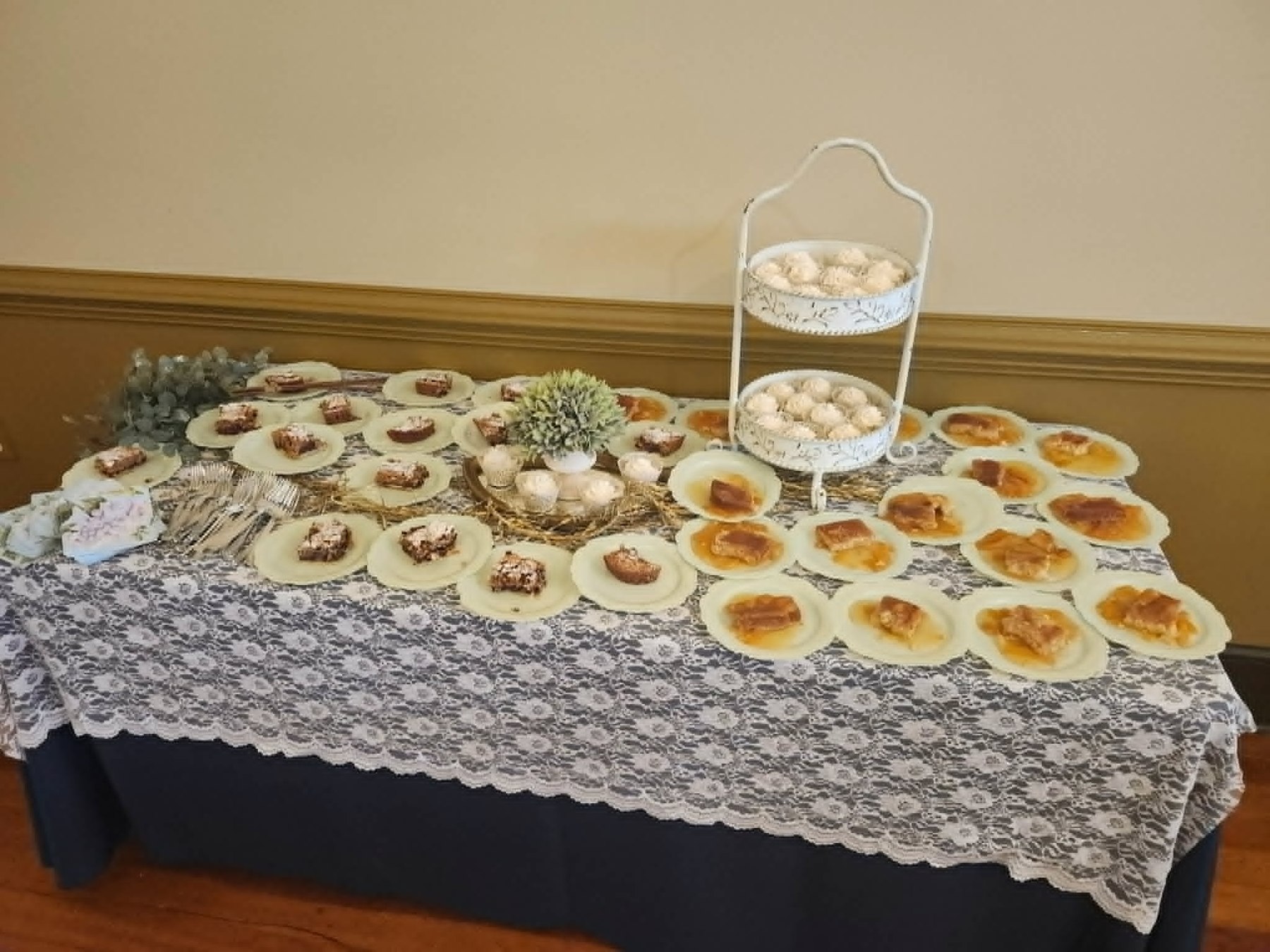 Dessert buffet arranged over lace linens with cookies and pastries