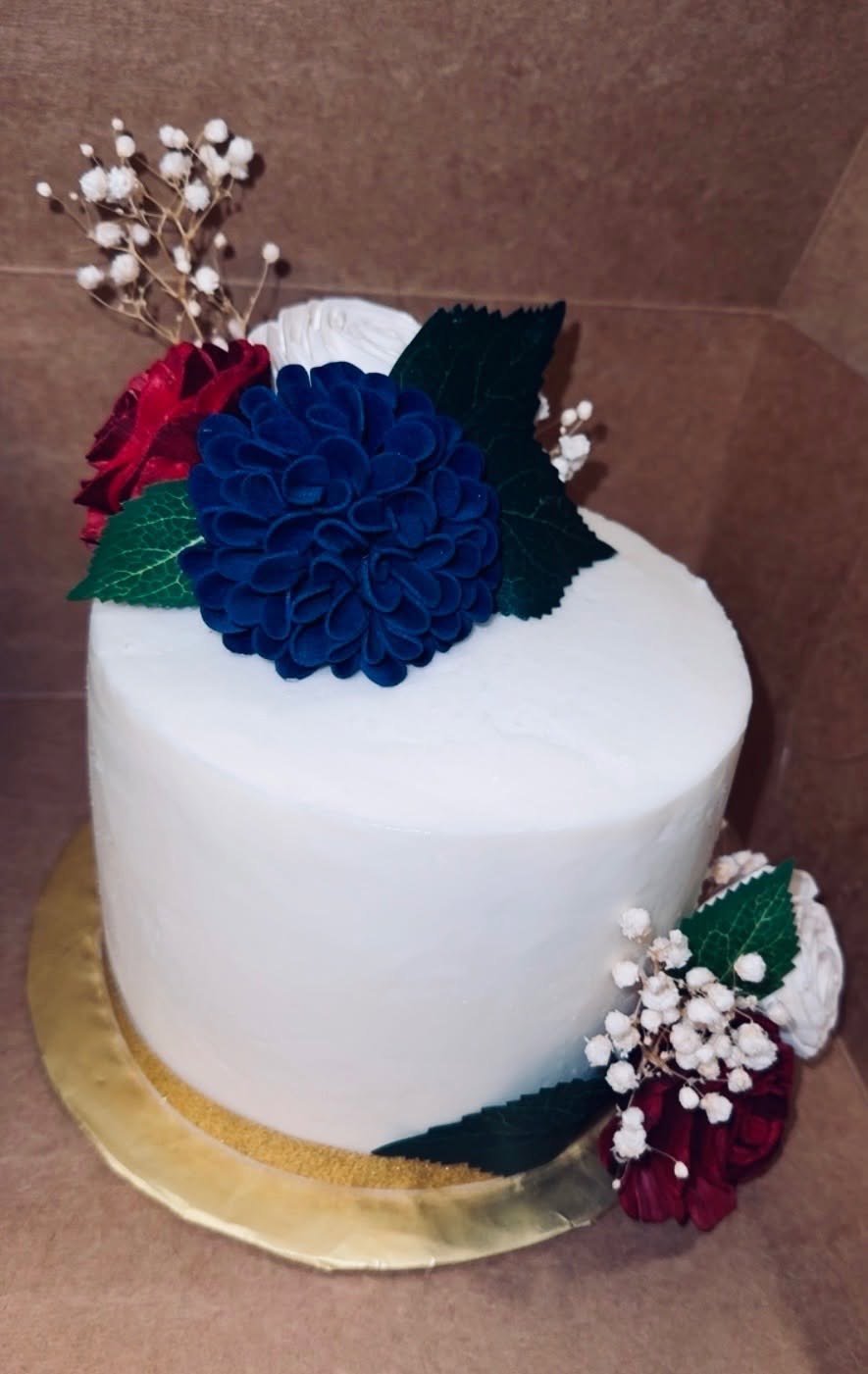 White cake accented with navy and red flowers