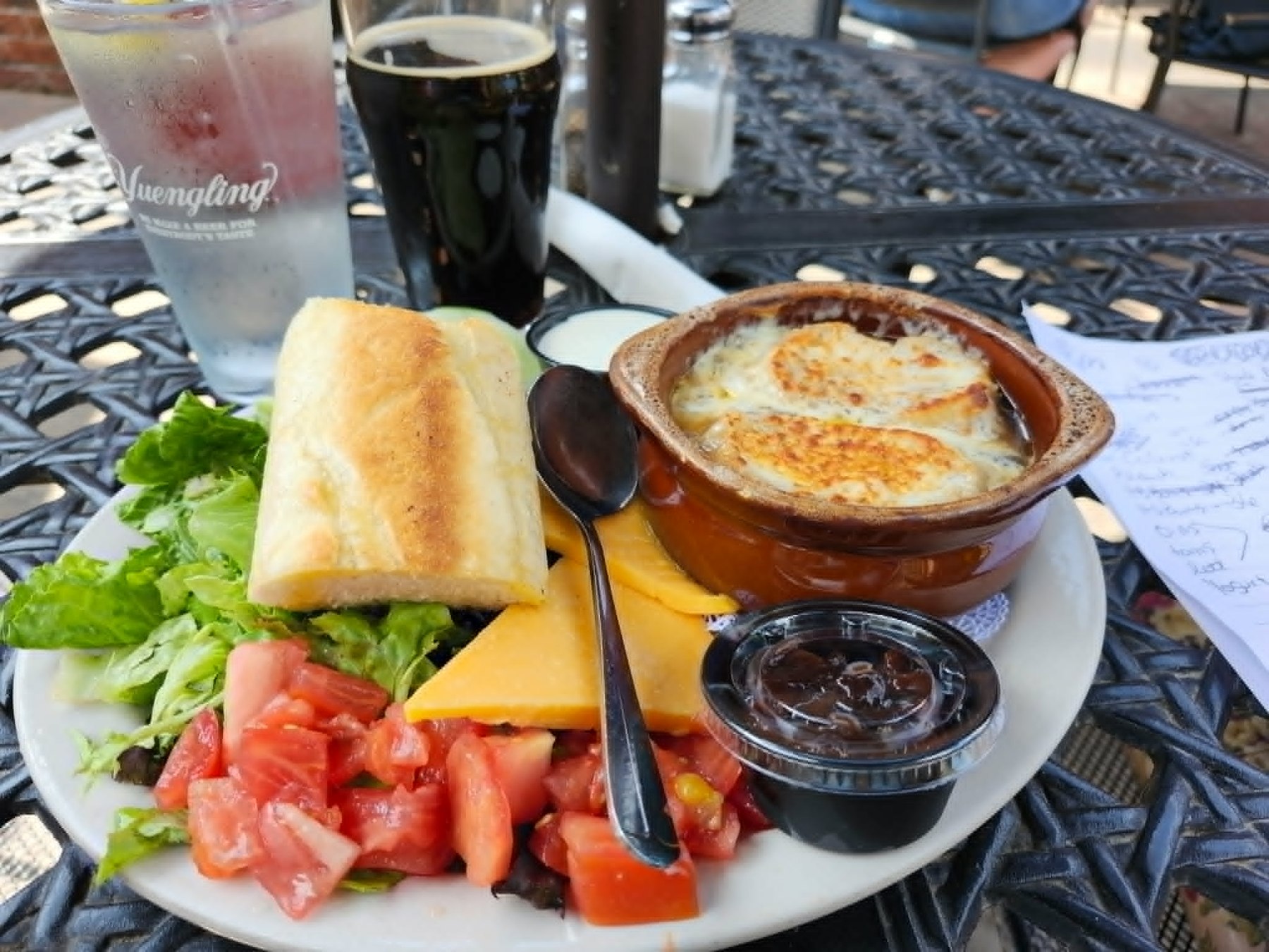 Plated soup, sandwich, salad, tomato, and cheese luncheon